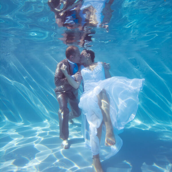 couple de mariés pris en photo sous l'eau dans une piscine