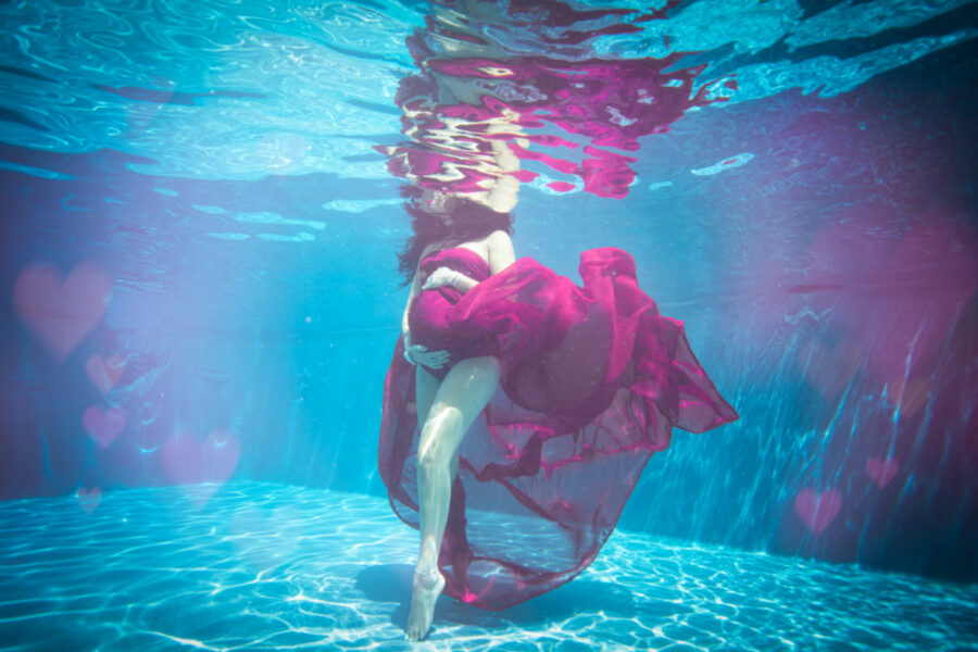 Photo d'une femme en robe violette dans une piscine sous l'eau