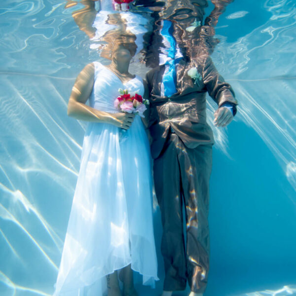 couple de mariés pris en photo sous l'eau dans une piscine