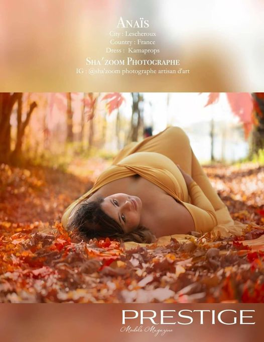 photo d'une femme enceinte avec une robe jaune, allongée dans les feuilles d'une forêt automnale